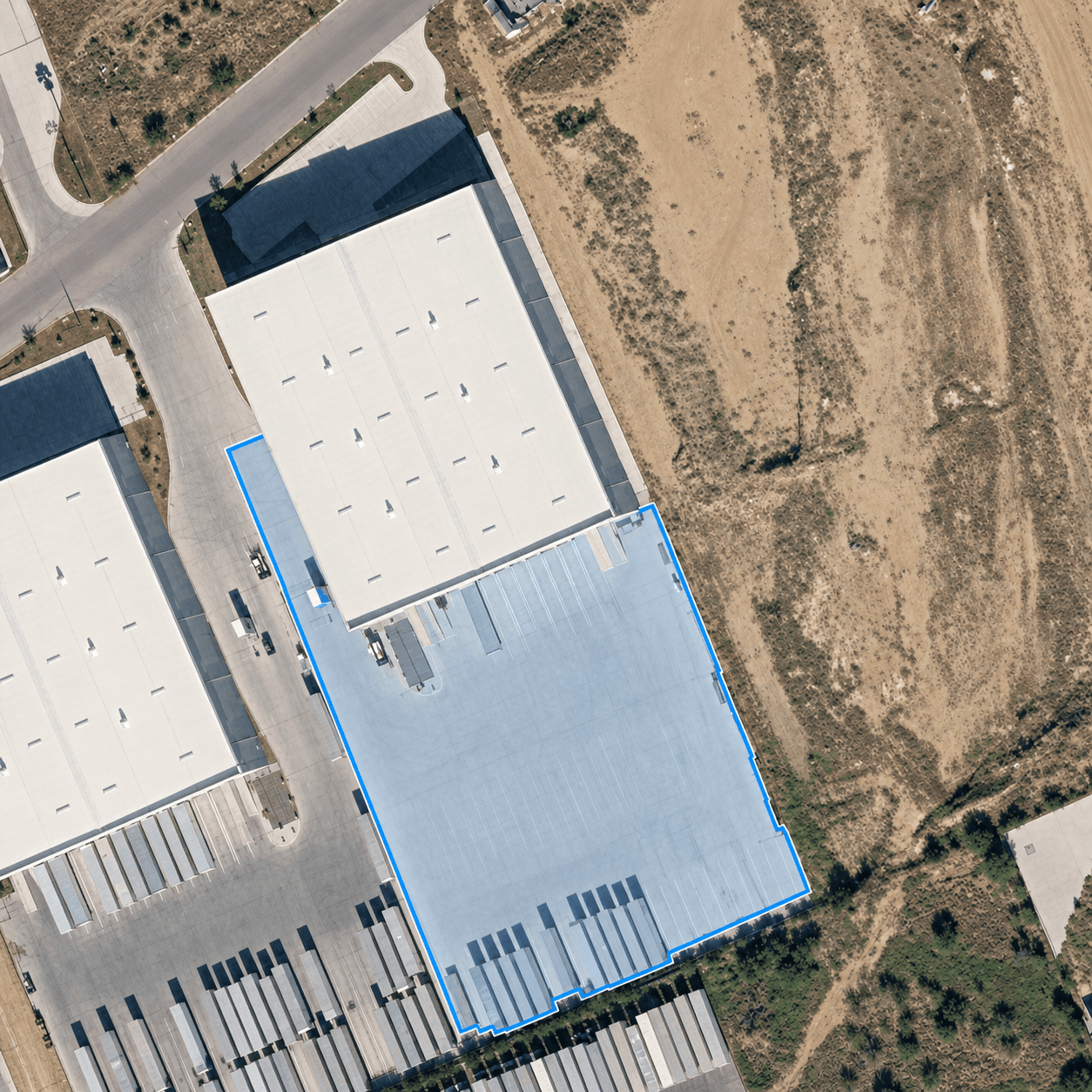 Aerial view of the Distrubi 100,000 sq ft Laredo, TX warehouse with 15 dock doors and 80-spot trailer yard outlined in blue